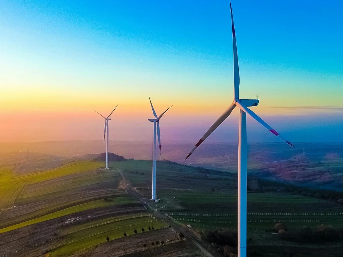 Wind turbines on rolling hills at sunset