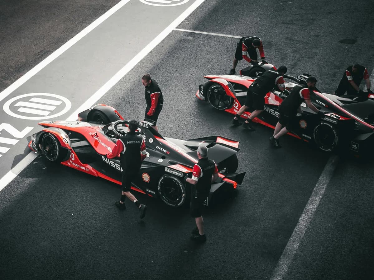 Race-car pit crew working on cars on a circuit