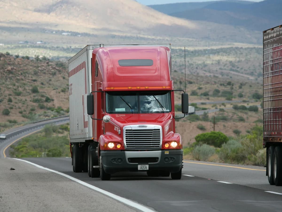 Red long-haul truck on a desert highway